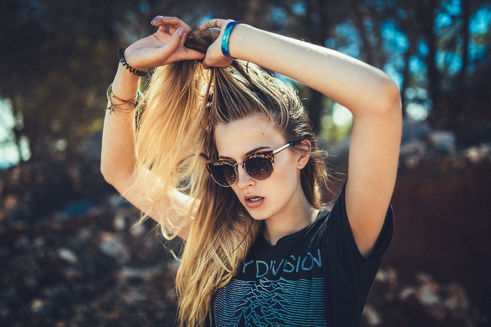 Woman with blonde hair wearing sunglasses and Joy Division t-shirt
