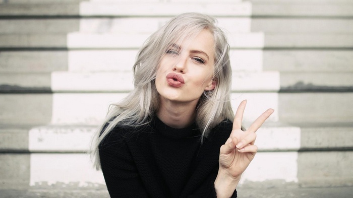 Agnes Hedengård pouting and making a peace sign on stairs