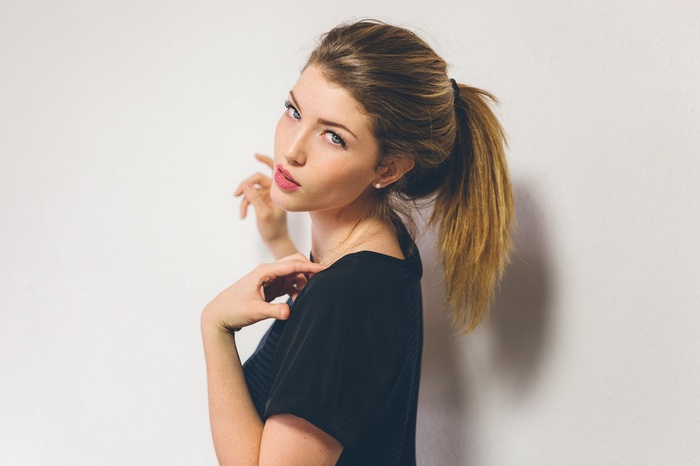 Woman with brown hair in a ponytail wearing a black t-shirt