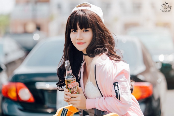 Woman in pink jacket holding a Desperados beer bottle