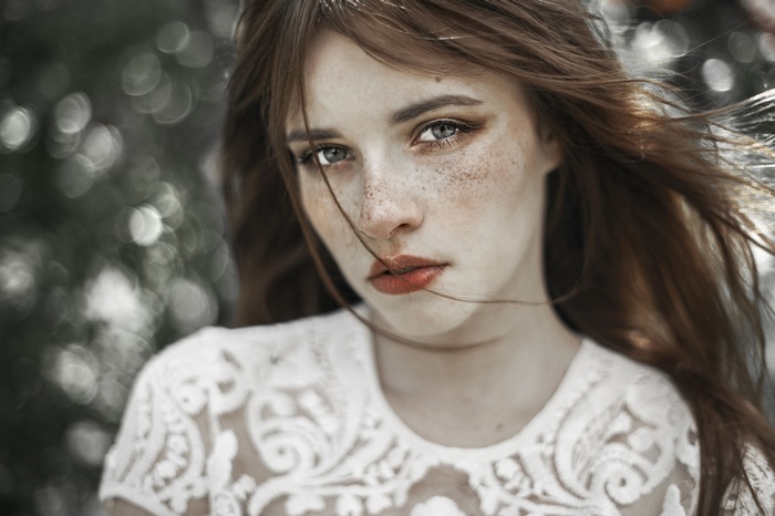 Woman with freckles and red lipstick in the wind