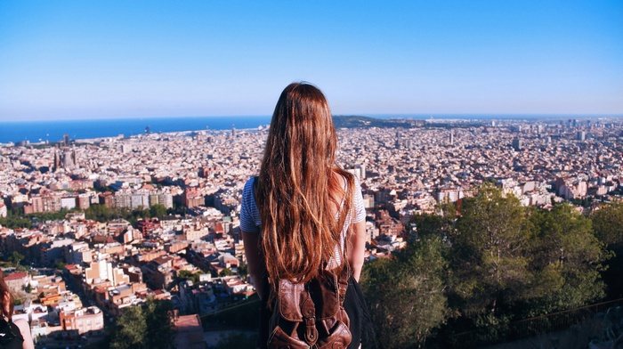 Woman overlooking Barcelona cityscape from a hill