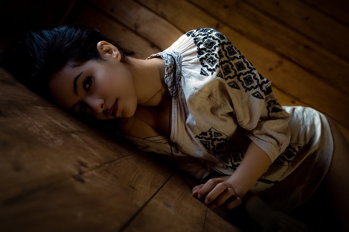 Woman with black hair lying on wooden floor