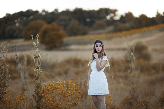 Woman in white dress with headband in a field
