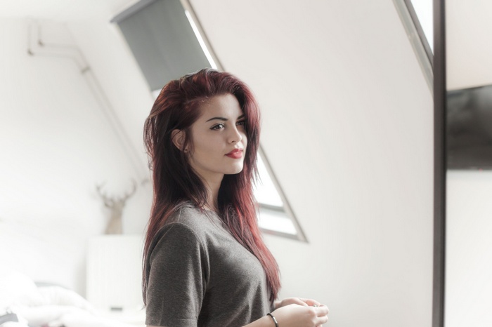 Woman with red hair and red lipstick looking away