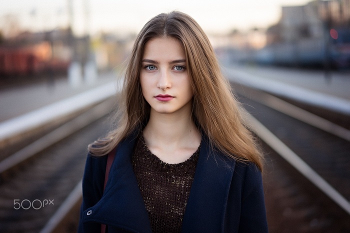 Woman in blue coat on railway track