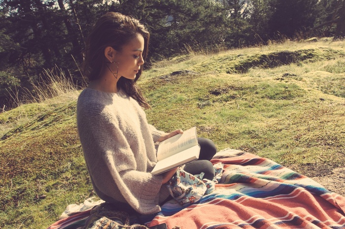 Nathalie Kelley reading a book outdoors