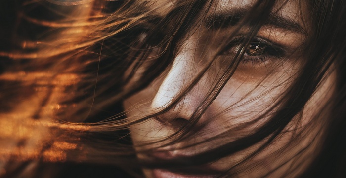 Close-up portrait of a woman with hair blowing