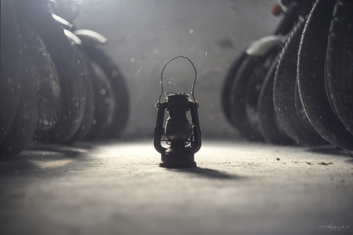 Old lantern between motorcycle tires