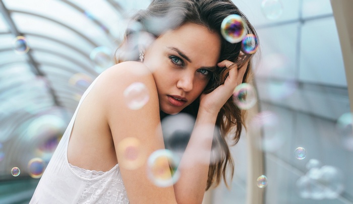 Woman with blue eyes surrounded by bubbles