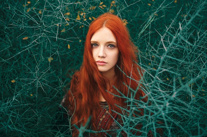 Redhead woman with long hair in thorns