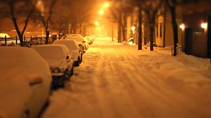 Cars parked on a snowy street at night