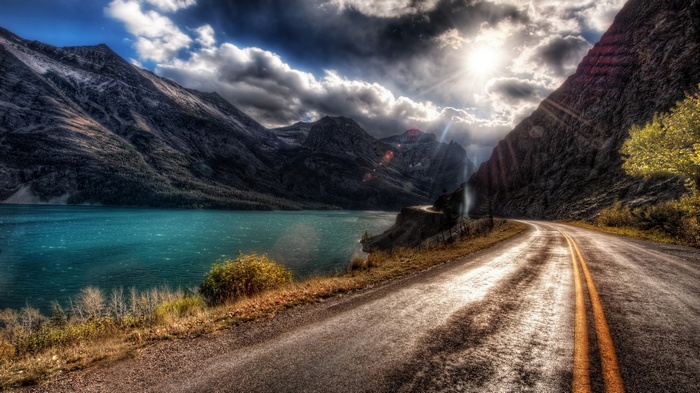 Road alongside a turquoise lake and mountains