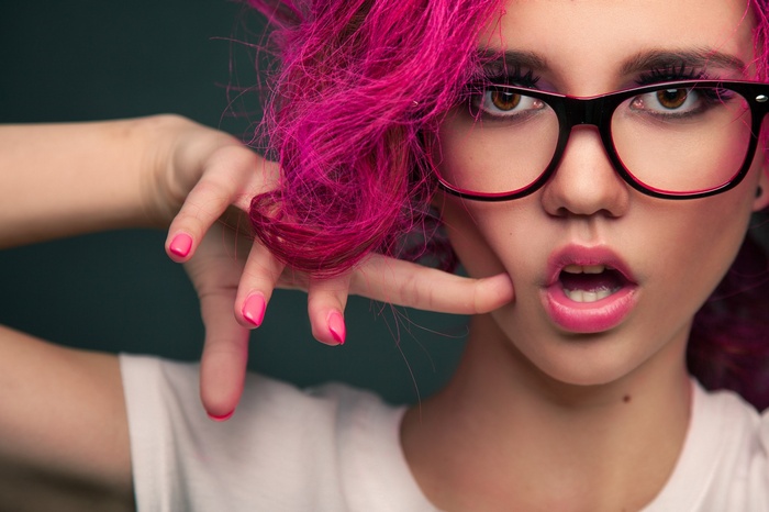 Woman with pink dyed hair and glasses