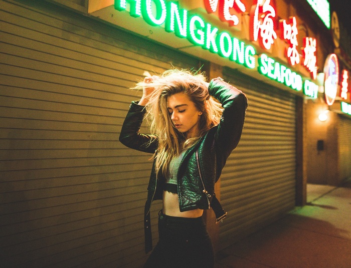 Woman in leather jacket in front of Hong Kong Seafood City sign