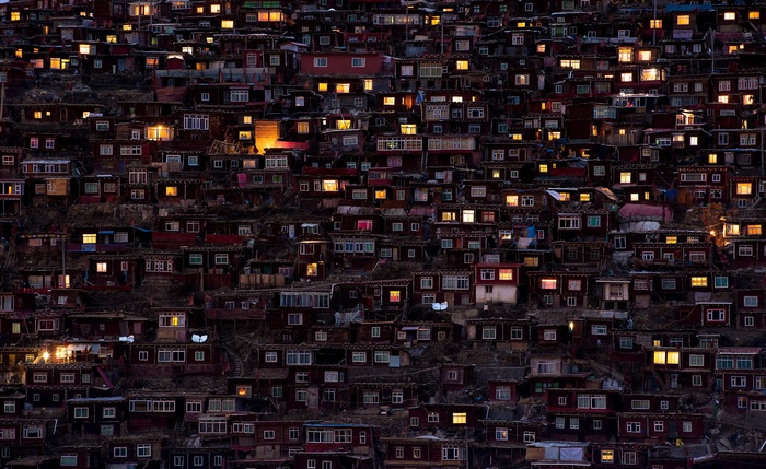 A hillside densely packed with illuminated houses at dusk