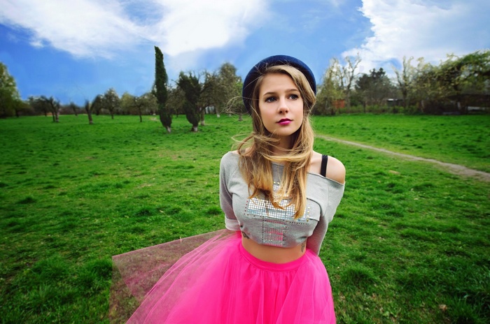 Marta Wierzbicka in a pink skirt and grey top outdoors