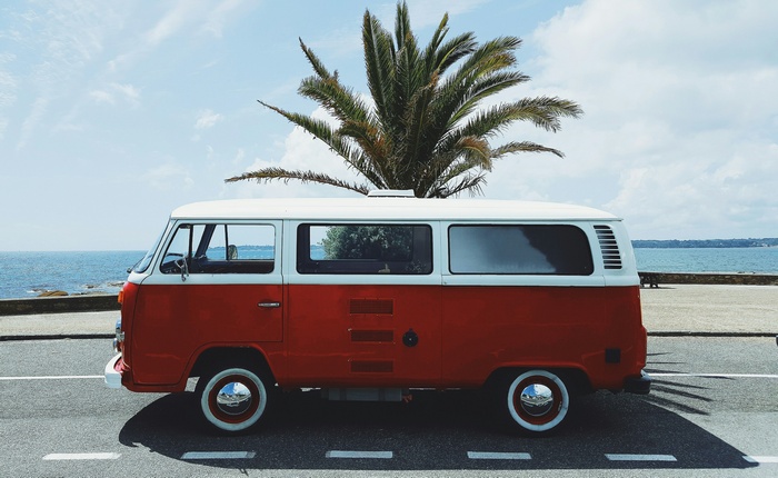 Red and white VW bus parked by the sea in Concarneau, France