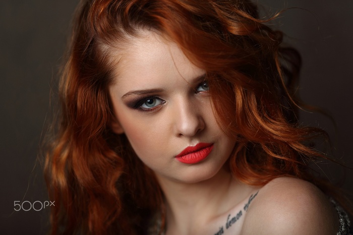 Portrait of a redhead woman with blue eyes and red lipstick