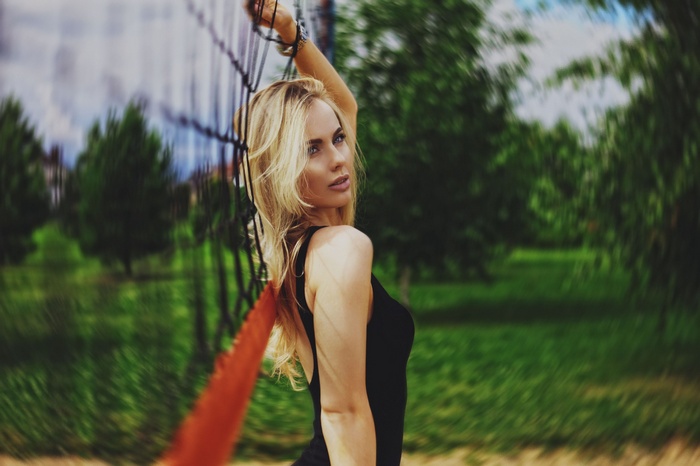 Woman with blonde hair in black clothing outdoors