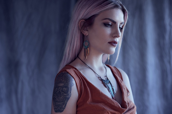 Woman with pink hair and skull tattoo