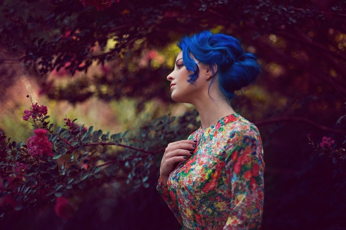 Woman with blue hair in a floral dress outdoors