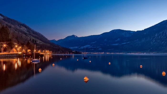 Lake Zug at night with mountains and boats