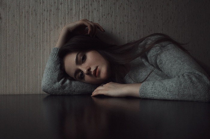 Woman with red lipstick and black nails wearing a sweater