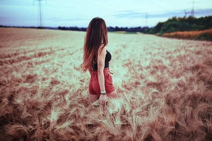 Woman in shorts standing in a wheat field