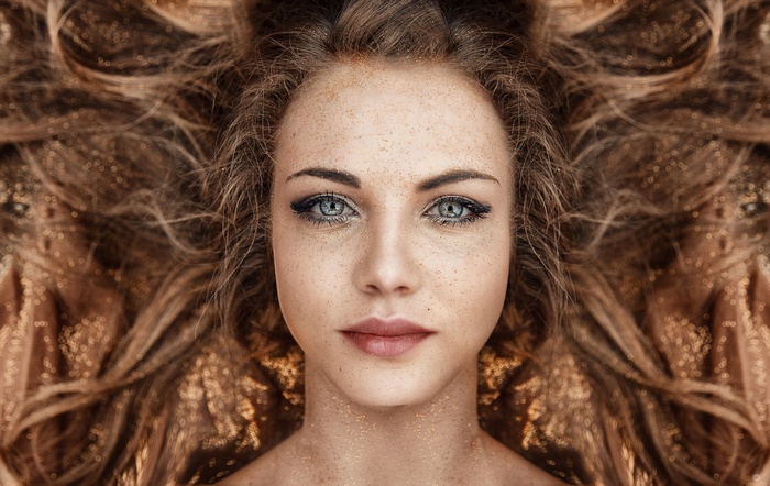 Portrait of a woman with freckles and glitter