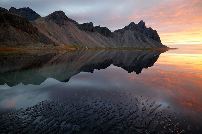Mountains reflected in water at sunset