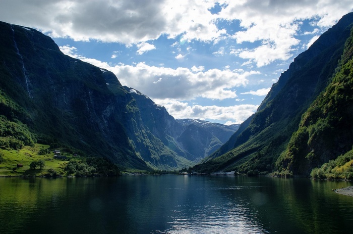 A serene fjord with mountains and clouds