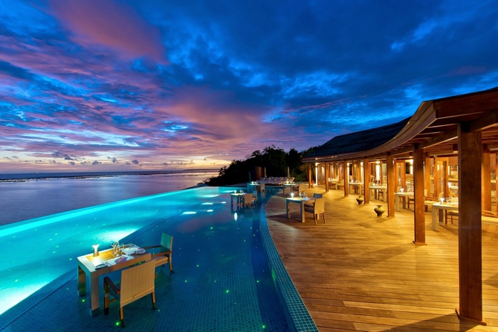 Infinity pool and restaurant at sunset