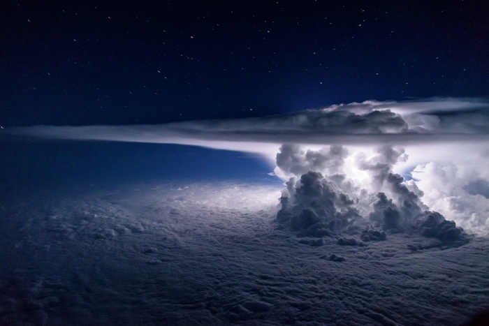 Lightning storm over clouds at night