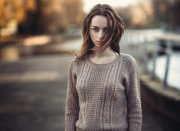 Woman with hair in face wearing a sweater