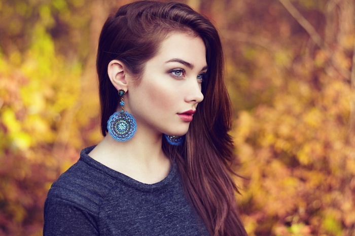 Woman with long brown hair and blue earrings