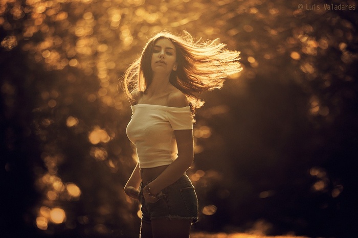 Brunette model in white top and denim shorts outdoors