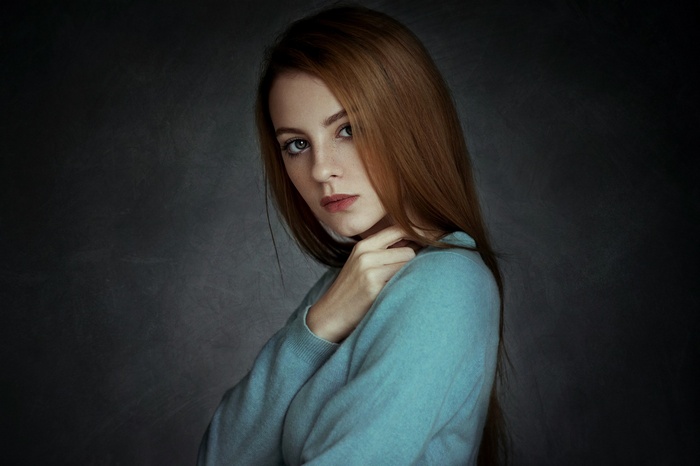 Woman with long auburn hair wearing blue clothing