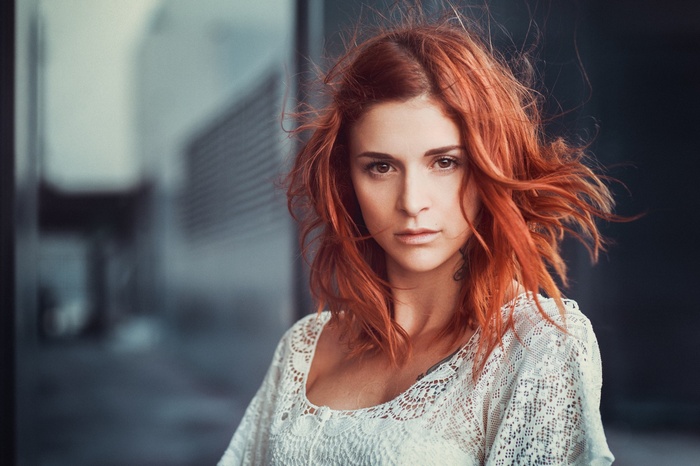 Redhead woman with windblown hair in a white top