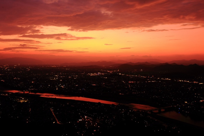 Cityscape at Sunset with River and Hills