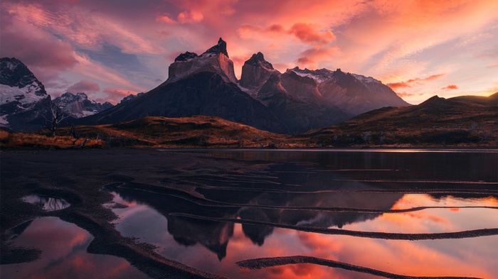 Torres del Paine mountains reflected in a lake at sunset