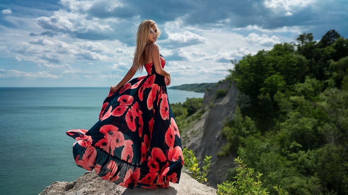 Woman in poppy dress on cliff by Ivan Gorokhov
