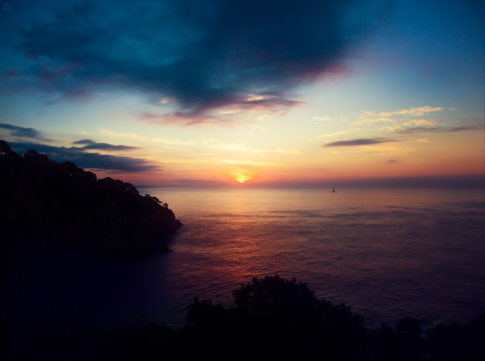 Sunset over the sea with a distant boat