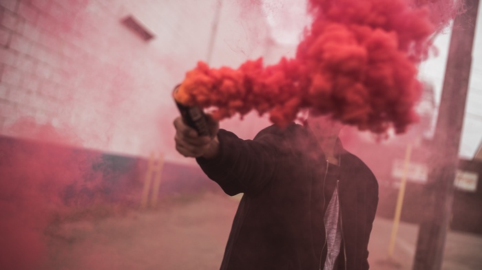 Person holding red smoke bomb
