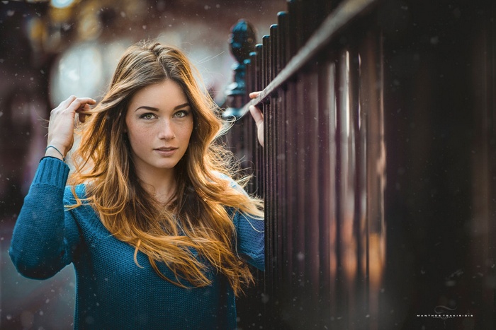 Woman with long hair by a fence, photography by Manthos Tsakiridis