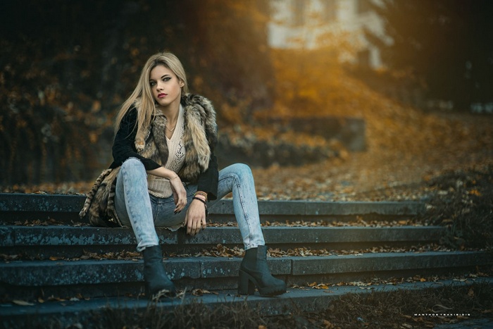 Woman with blonde hair sitting on stairs in fall