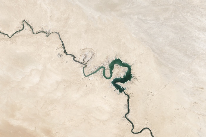 Satellite view of a river forming a heart shape in a desert