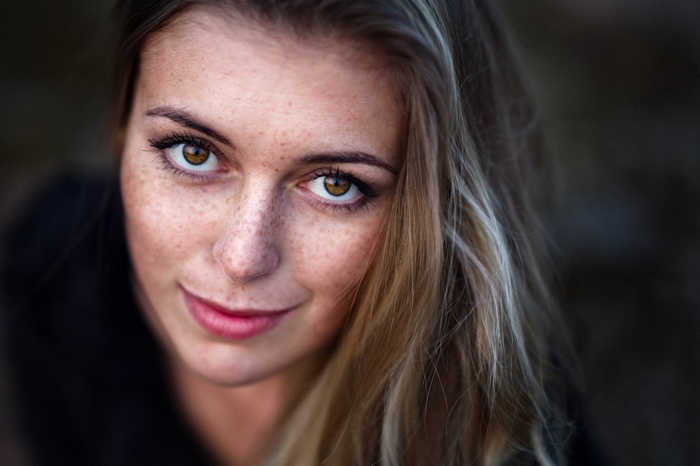 Woman with freckles and blonde hair looking at viewer