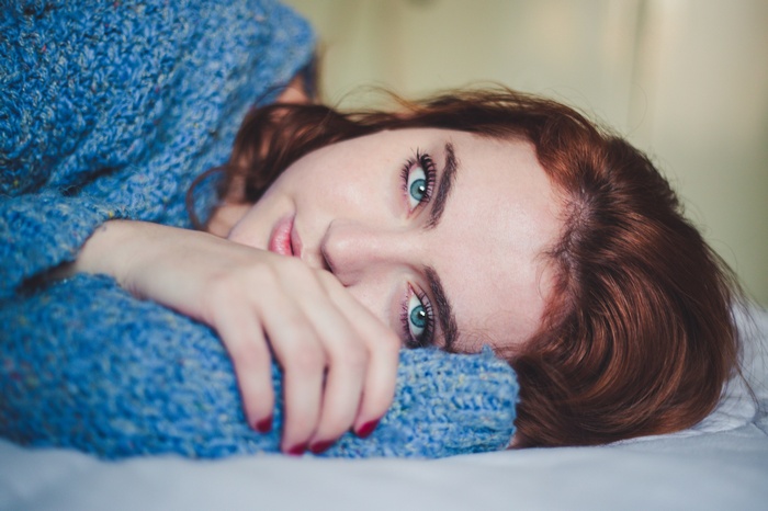 Woman with red hair and blue eyes in a blue sweater