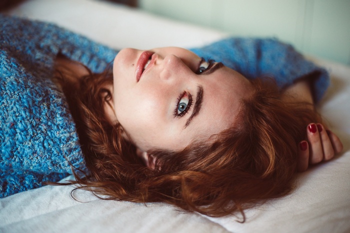 Woman with blue eyes and red hair in a blue sweater